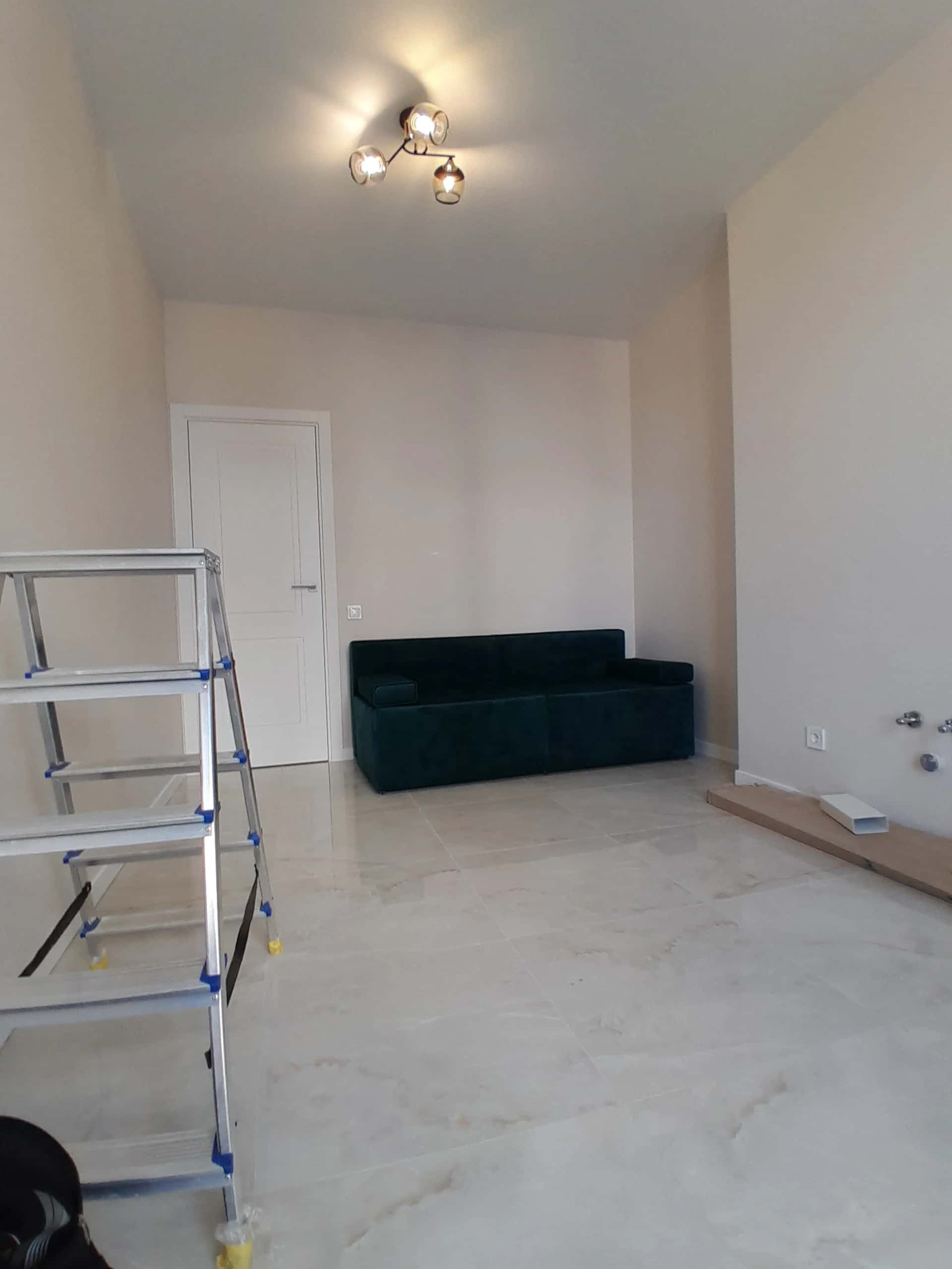 Living room with white marble-look porcelain tile flooring and stretch ceiling
