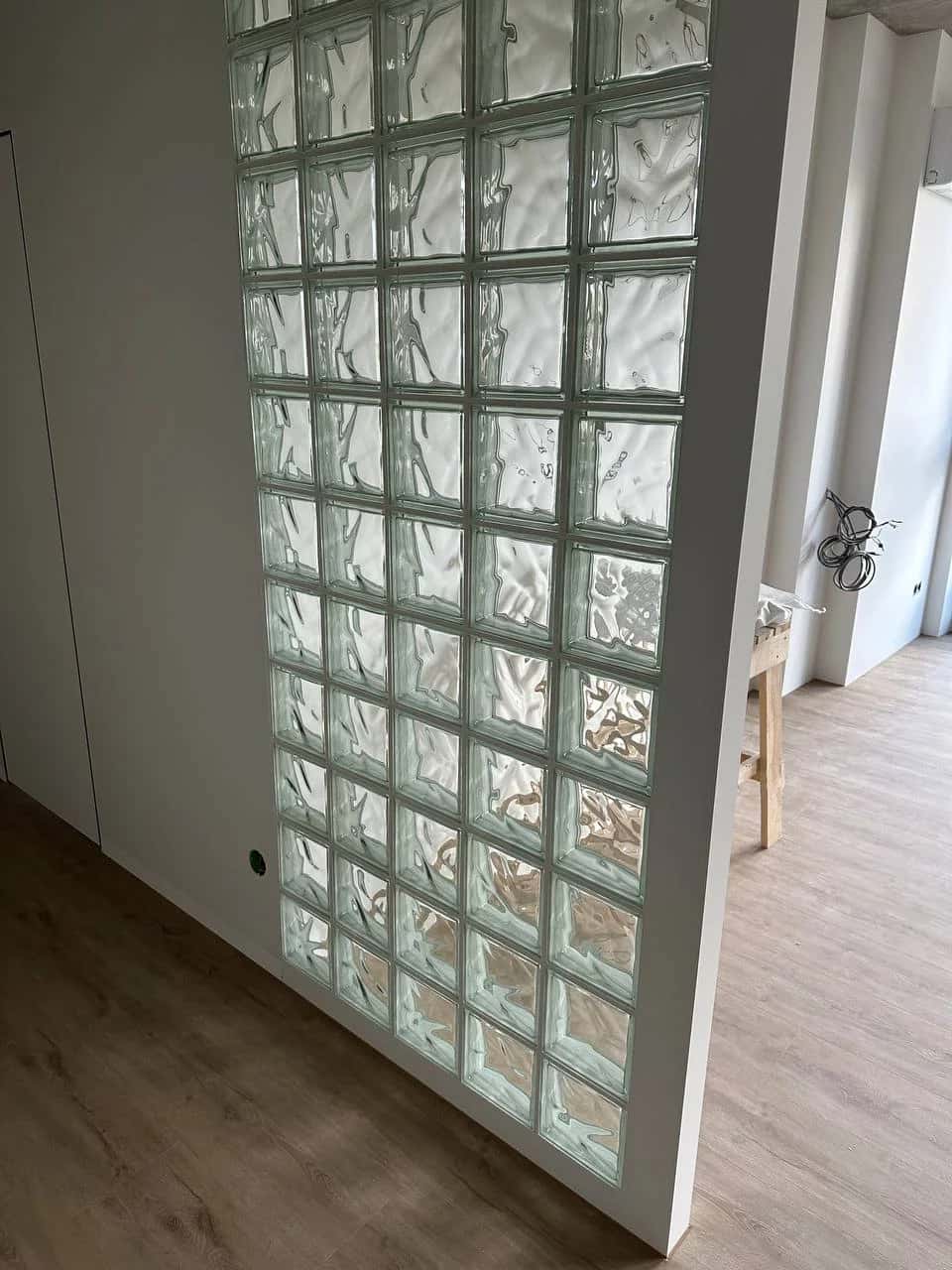 Glass block partition between rooms in an apartment, light green tint