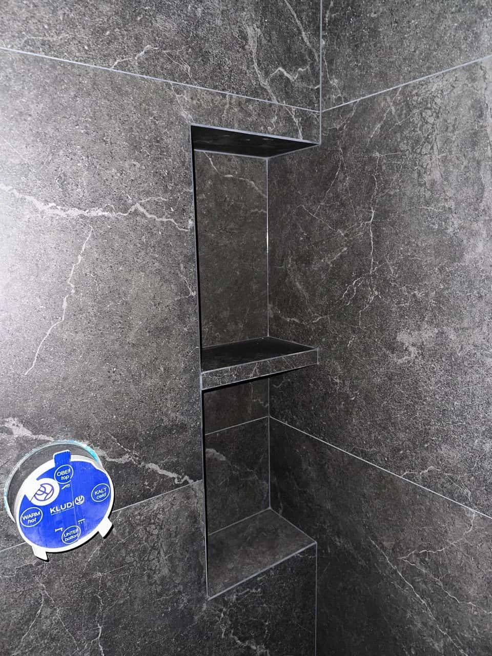 Shower enclosure with built-in two-shelf niche, dark marble-look porcelain tile