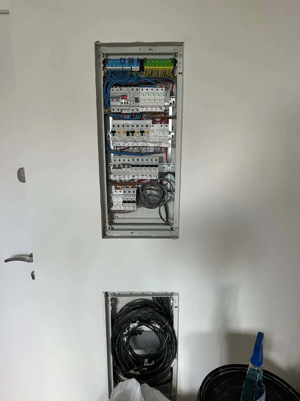 Apartment electrical panel with circuit breakers and RCDs on DIN rails, recessed into the wall