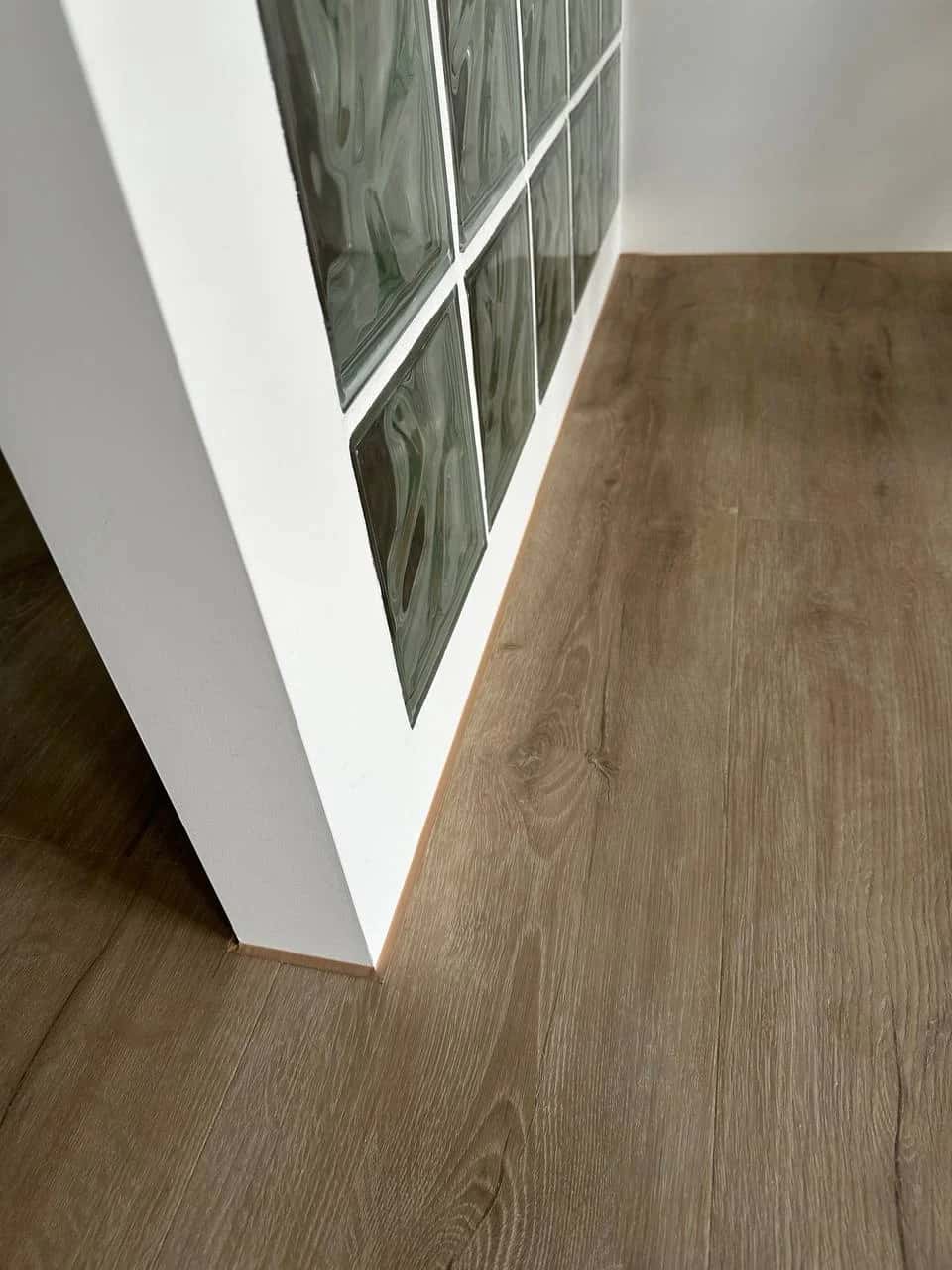Oak-look vinyl laminate flooring and glass block partition in the apartment