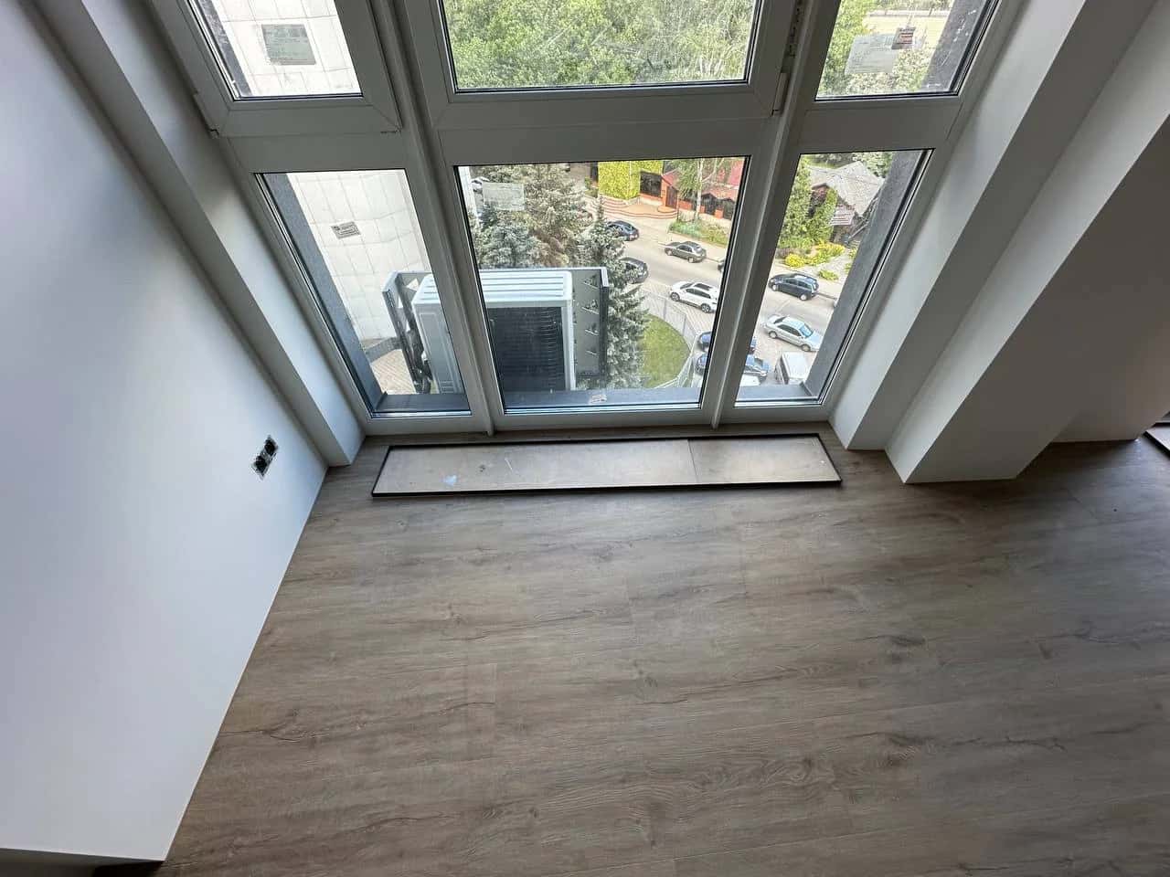 Room with panoramic glazing and grey-beige laminate flooring
