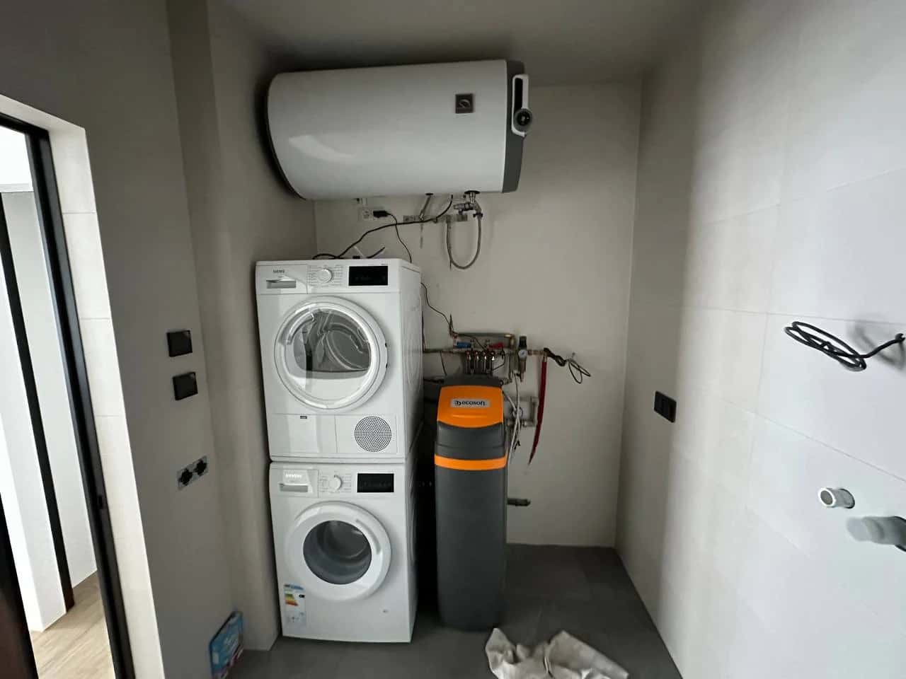 Utility room with a boiler, washing machine and Siemens stacked dryer, and an Ecosoft water filter