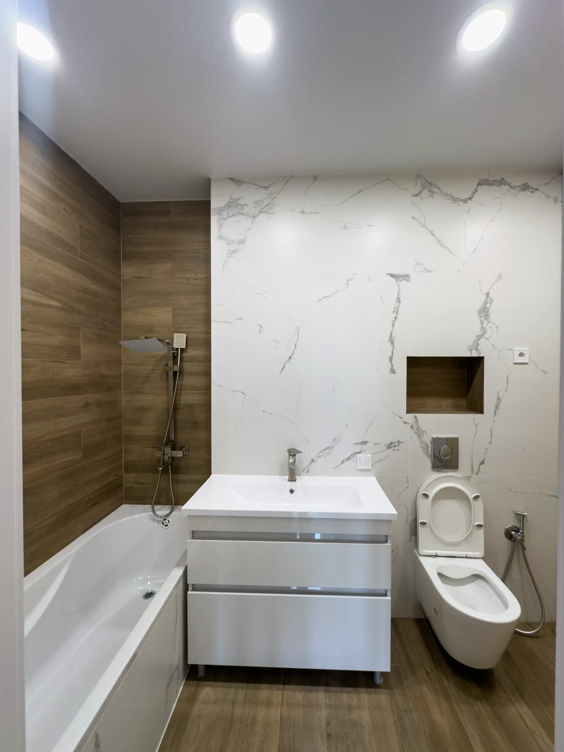 Bathroom with marble-effect porcelain tile on the accent wall and wood-effect tile on the floor and side wall