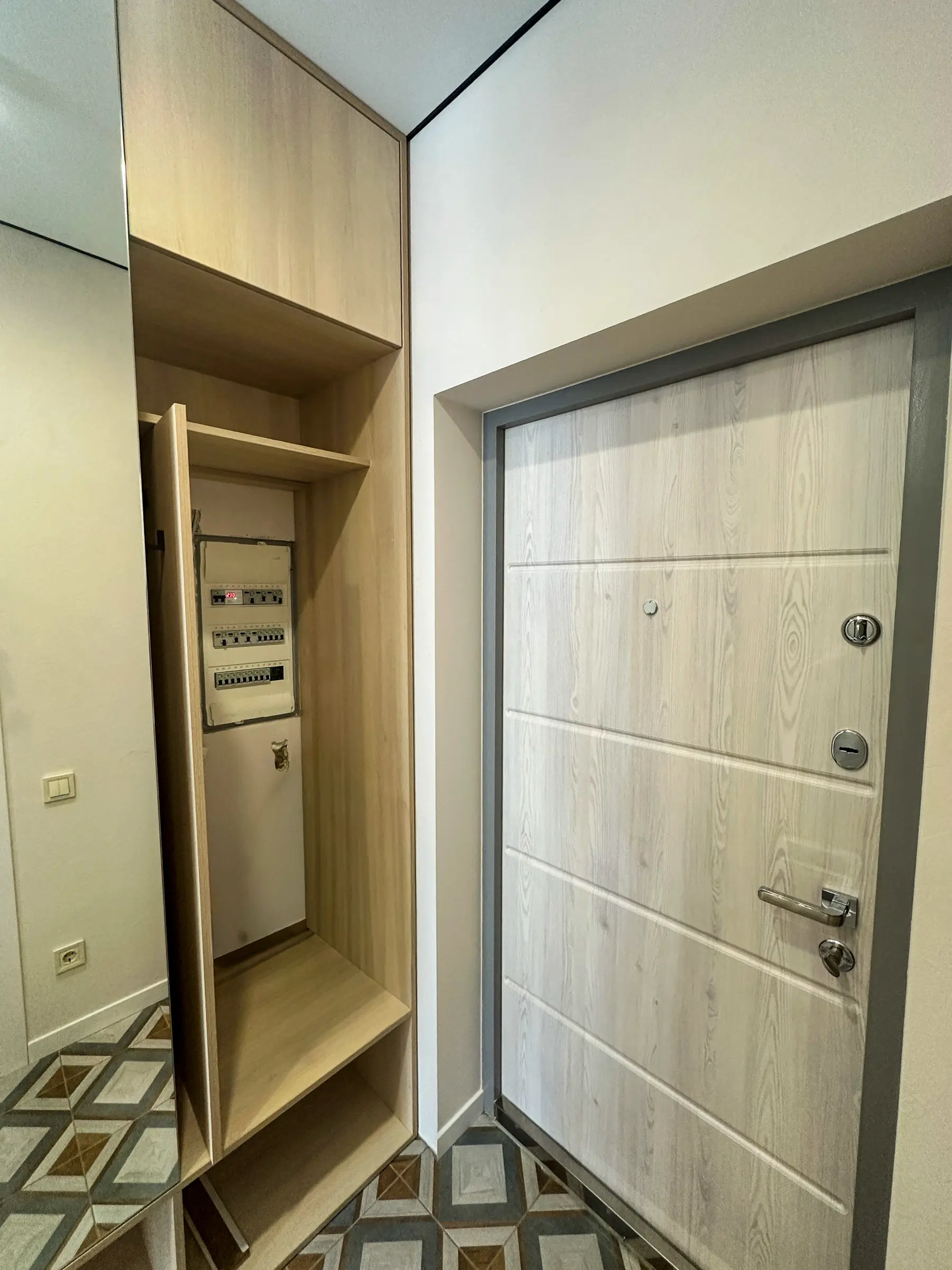 Entryway with a wood-effect built-in wardrobe and a concealed electrical panel behind a door