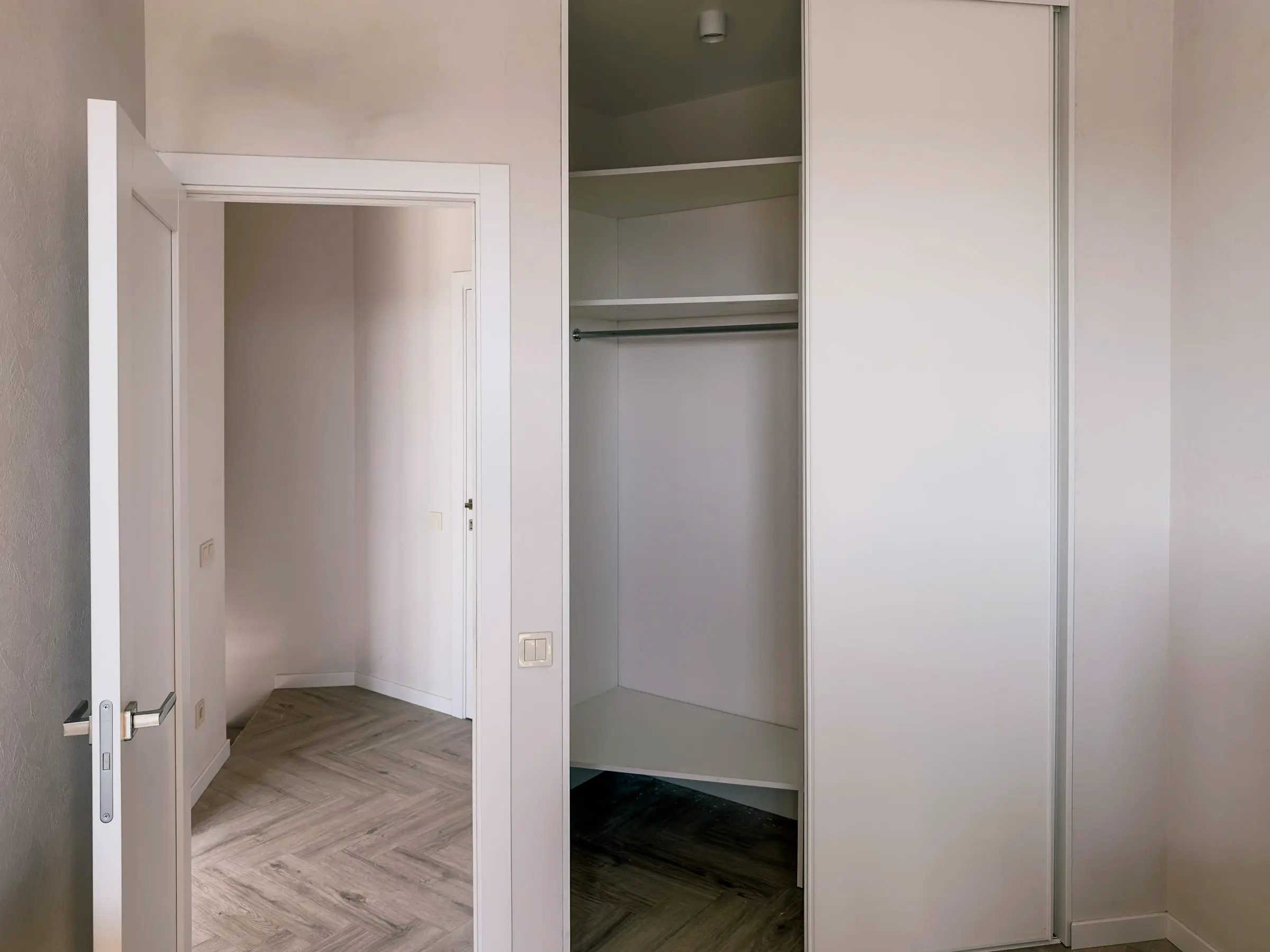 Bedroom: built-in sliding wardrobe with white doors and a clothing rail