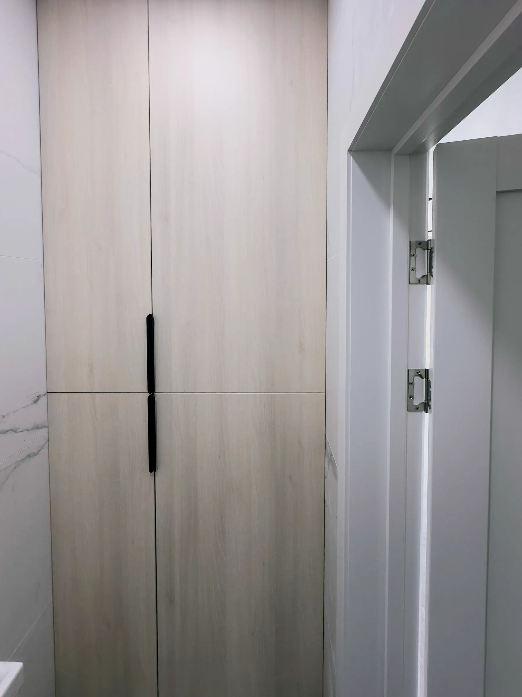 Hallway: built-in wardrobe with light wood-effect facades and black profile handles