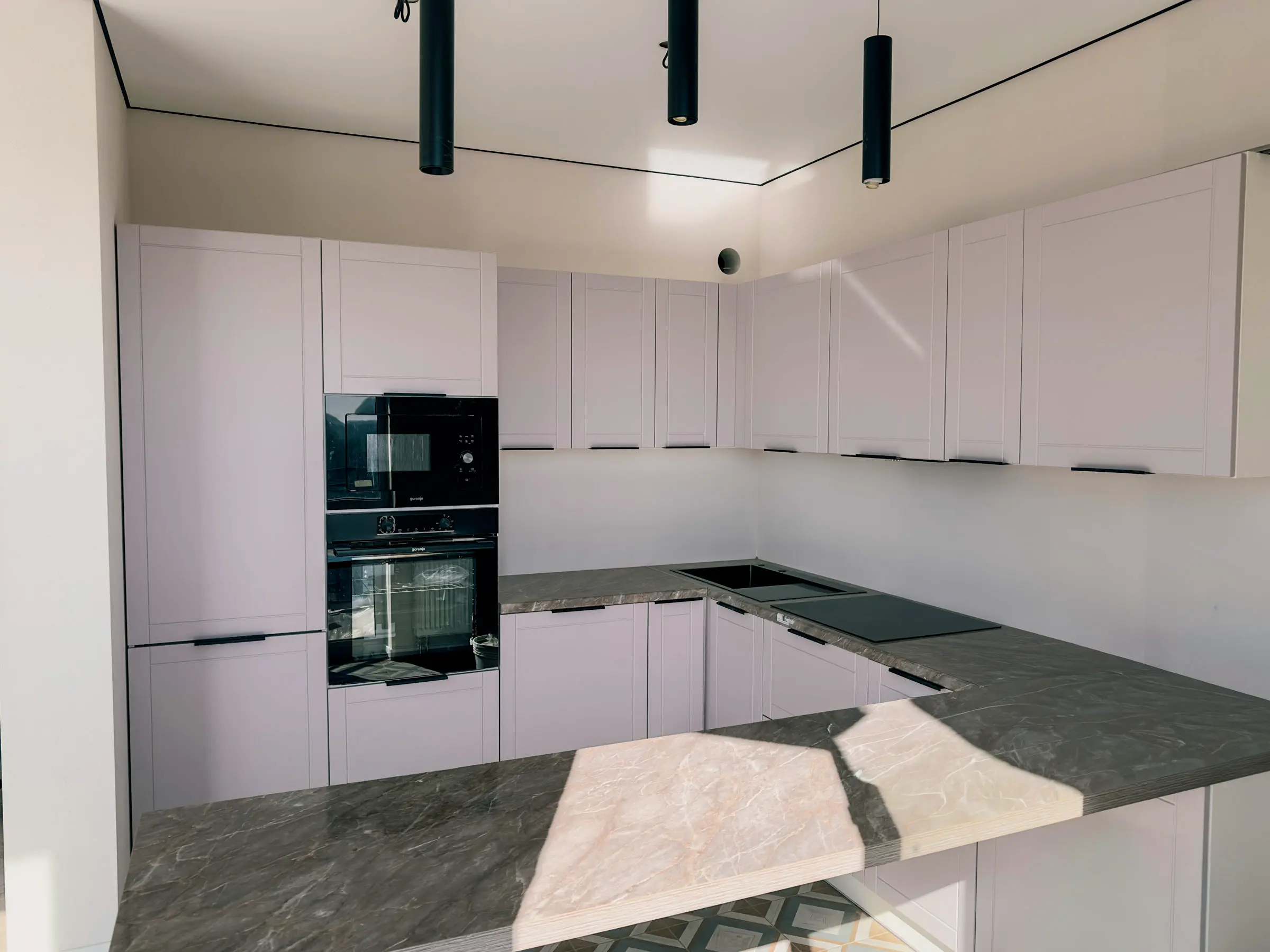 Kitchen with a corner set in lavender and dark marble-effect countertops