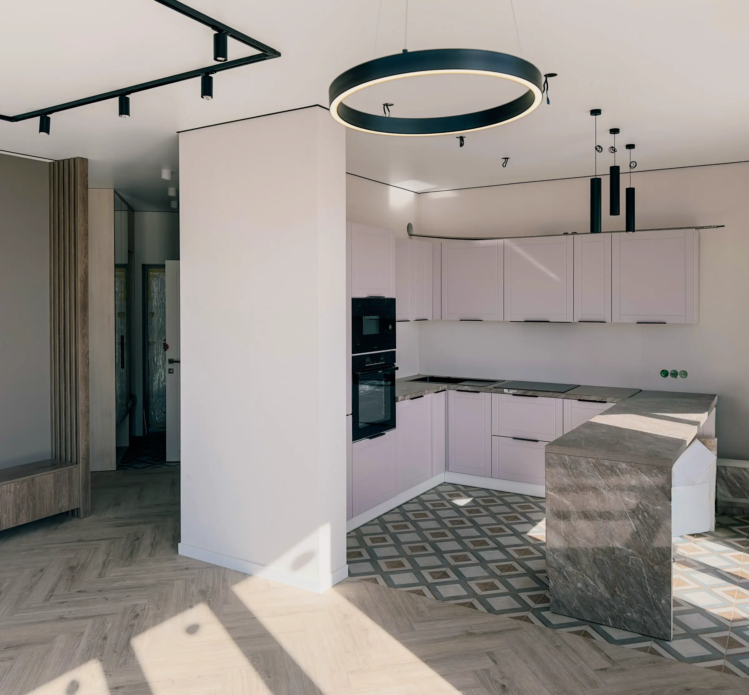 Kitchen-living room with a corner powder-toned set and a natural stone island