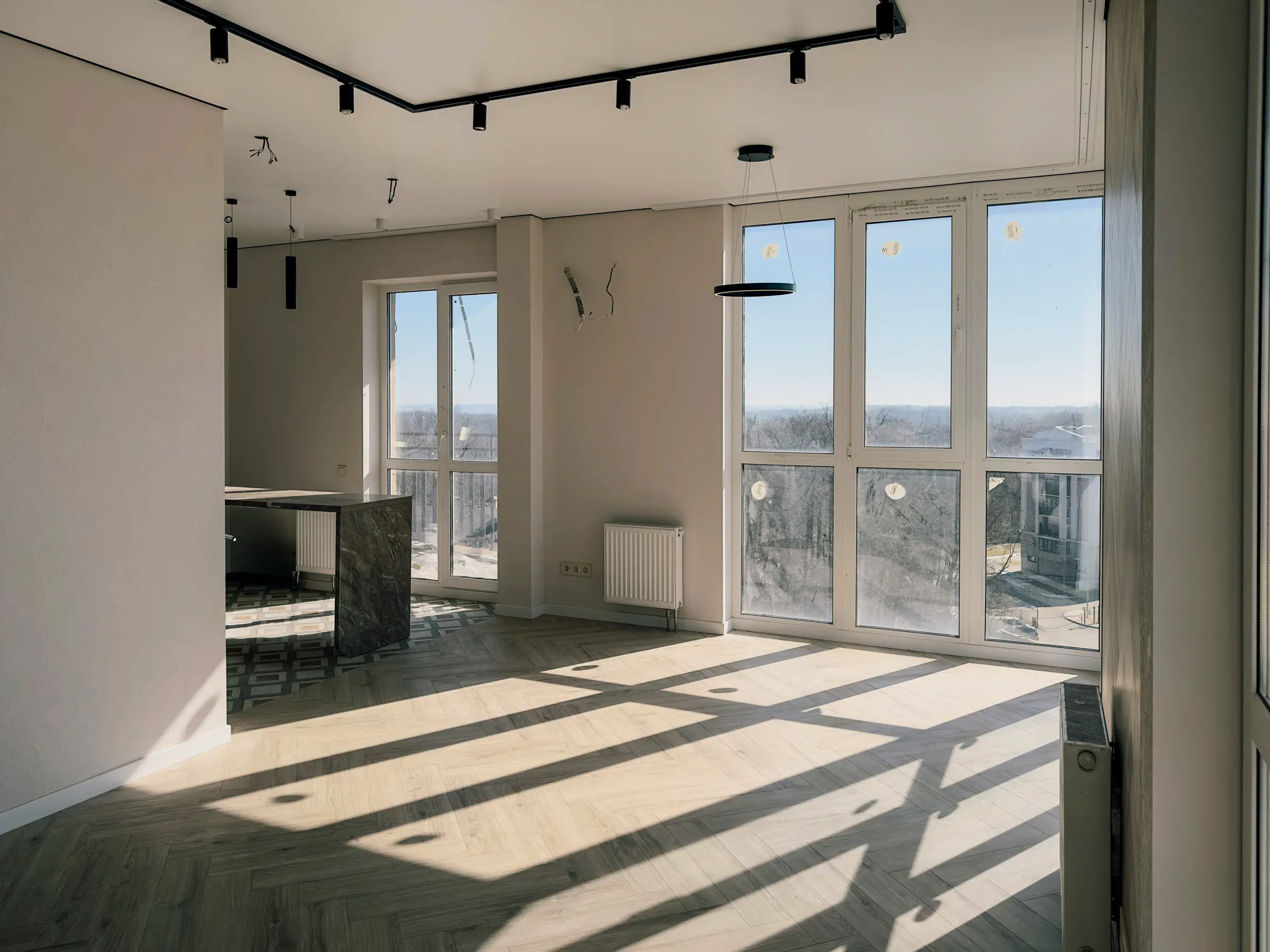 Living room with panoramic windows and a light-toned herringbone parquet floor