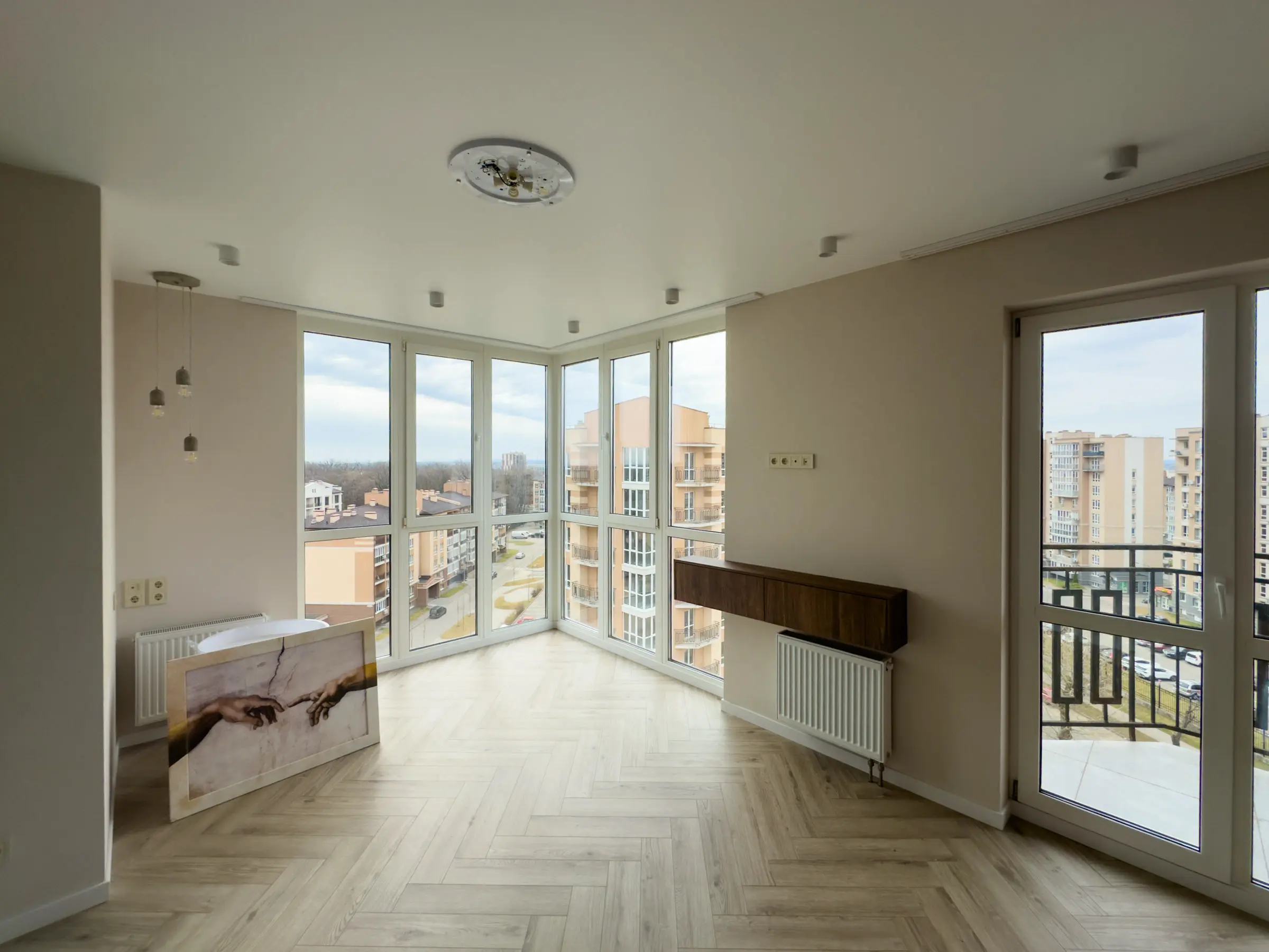 Living room with corner panoramic glazing and herringbone wood-effect porcelain tile flooring