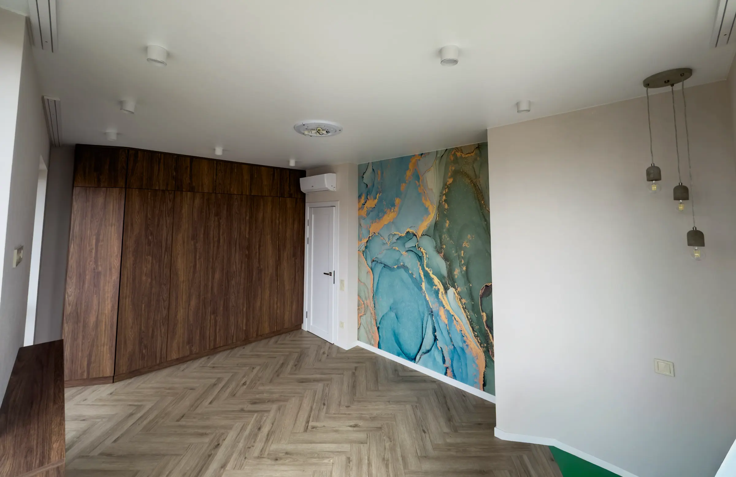 Bedroom with a built-in wardrobe in walnut-effect film and abstract teal-and-gold photo wallpaper